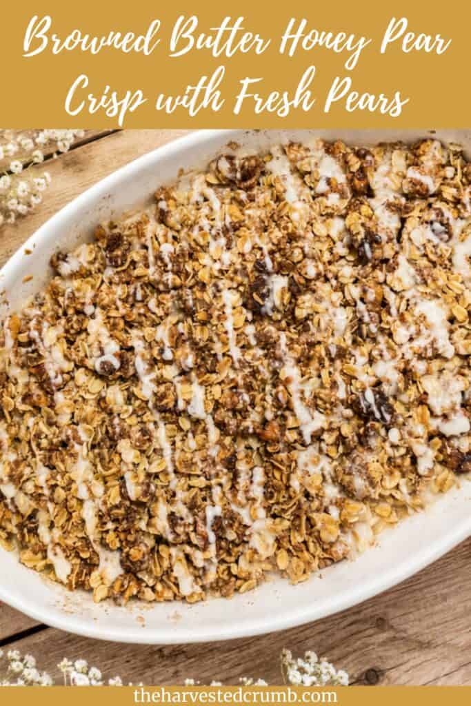 Pinterest pin: says Browned Butter Honey Pear Crisp with Fresh Pears at the top. Picture is of the honey pear crisp in a white baking dish. The bottom says theharverstedcrumb.com