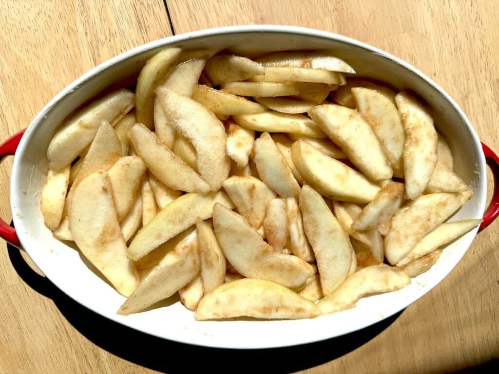 brown butter honey pear filling in a red and white baking dish on a wooden table