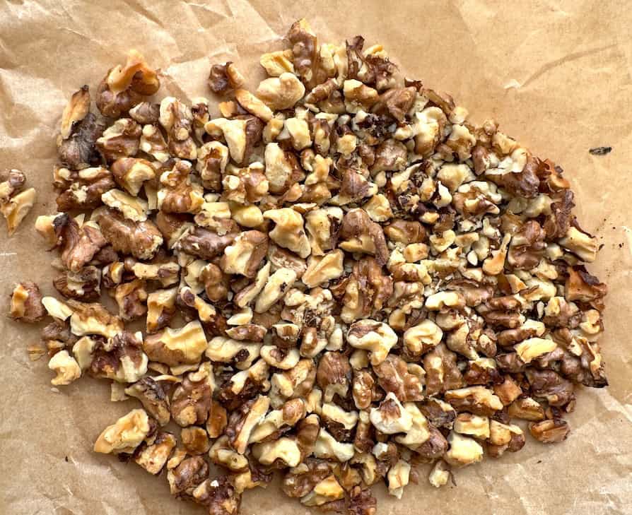 toasted walnut pieces on parchment paper