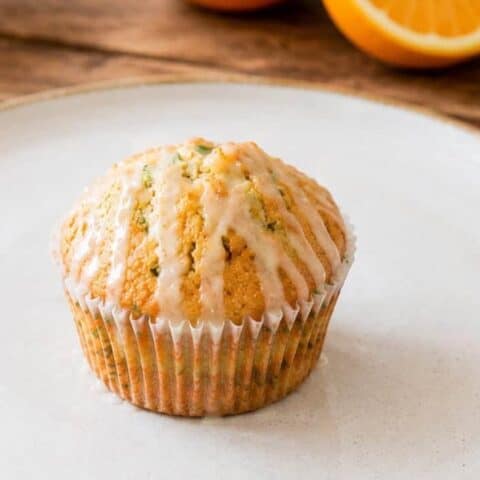 1 orange cardamom zucchini muffin on a white plate
