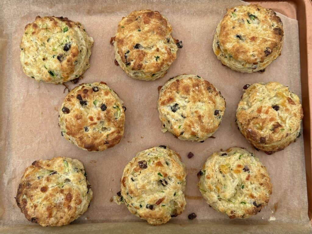 parchment lined baking tray with 9 ready to eat bacon cheddar zucchini biscuits